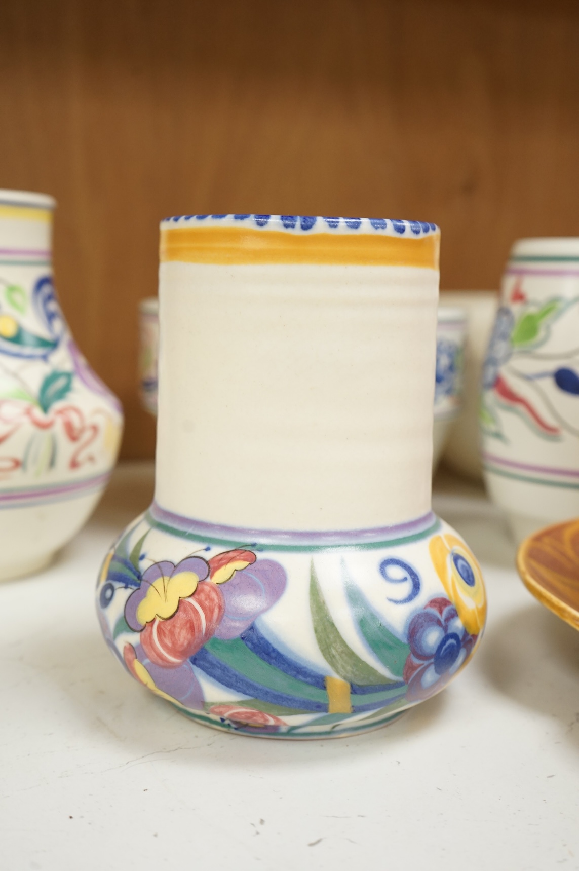 A collection of eight Poole pottery pieces to include vases, bowls and a jar and cover, largest 28cm in diameter